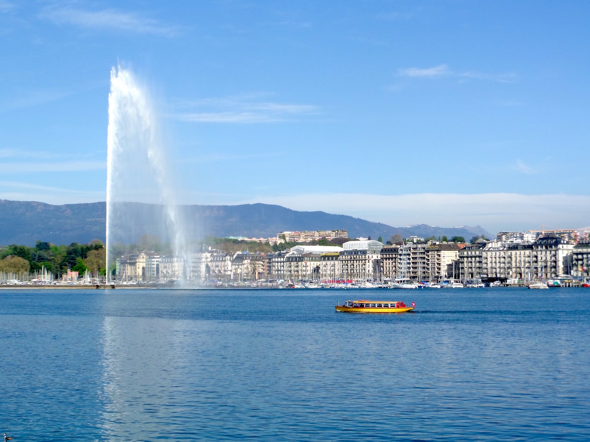 a large fountain spewing water into the air over a body of water, The Jet d’Eau Geneva