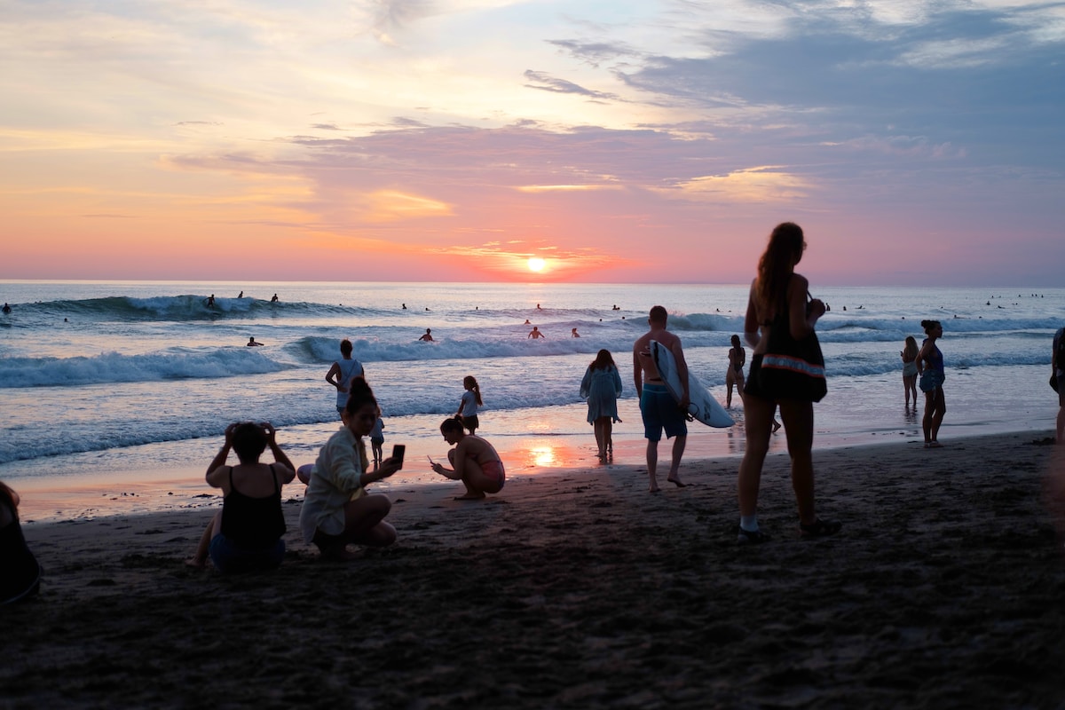 a group of people on a beach Watch the Sunset on the Beach Canggu Bali