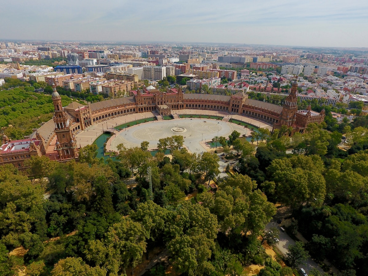 a bird's eye view of a city with a circular building - Parque de Maria Luisa Seville