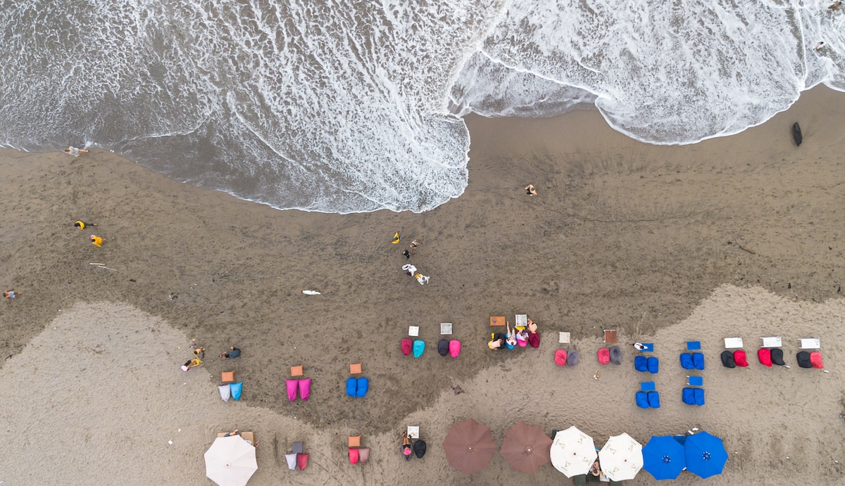 an aerial view of a beach with umbrellas and chairs Canggu Beach