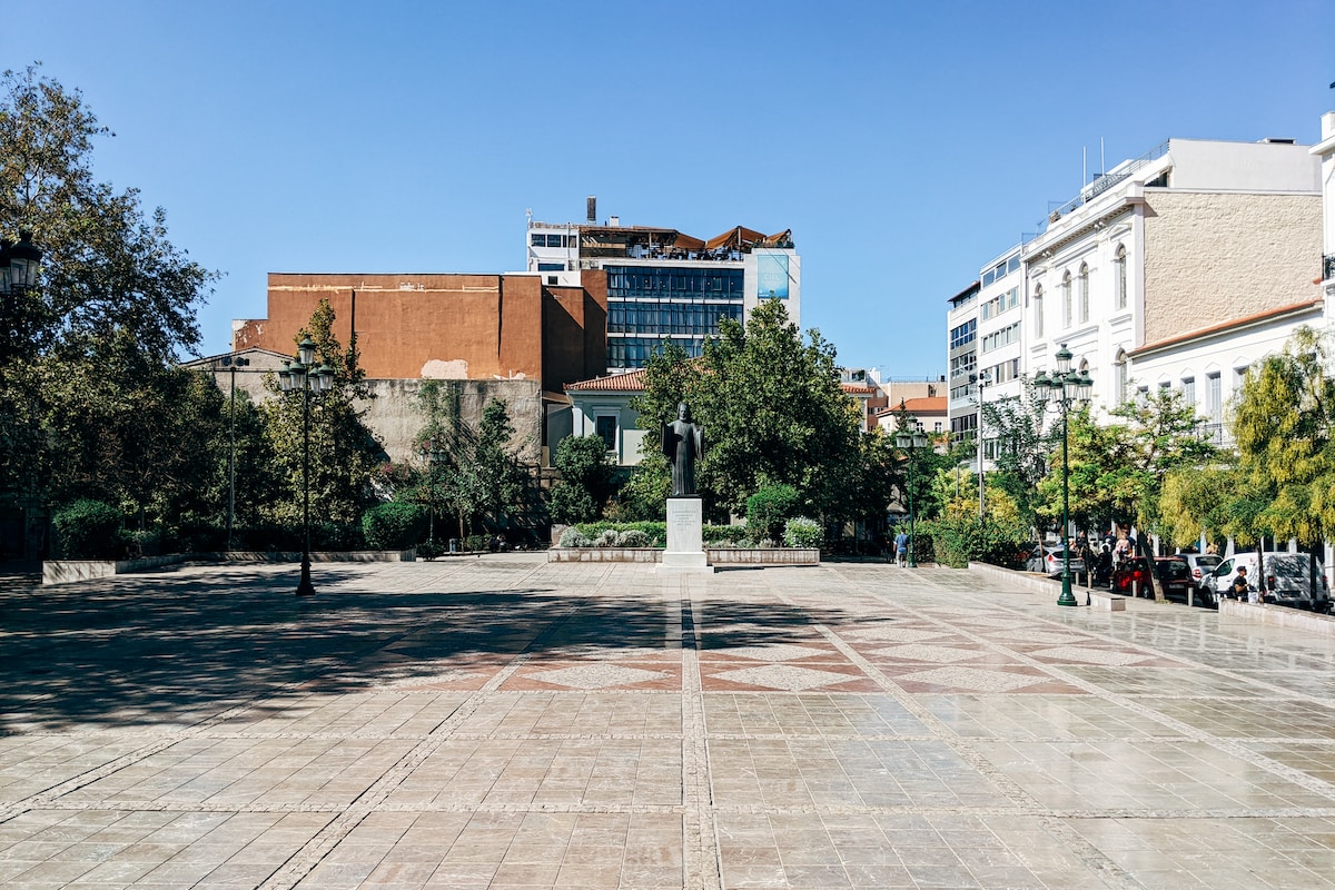 brown and white concrete building - Athens' Squares