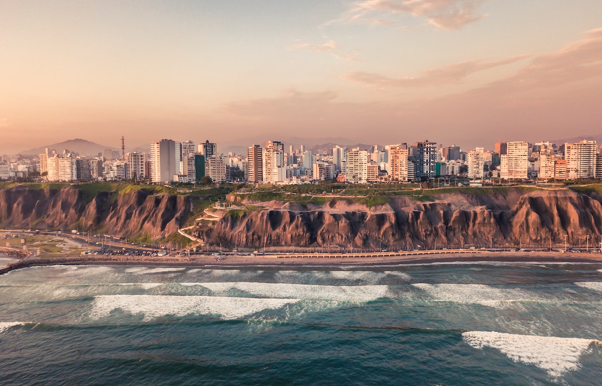 road near body of water and buildings at daytime - Lima