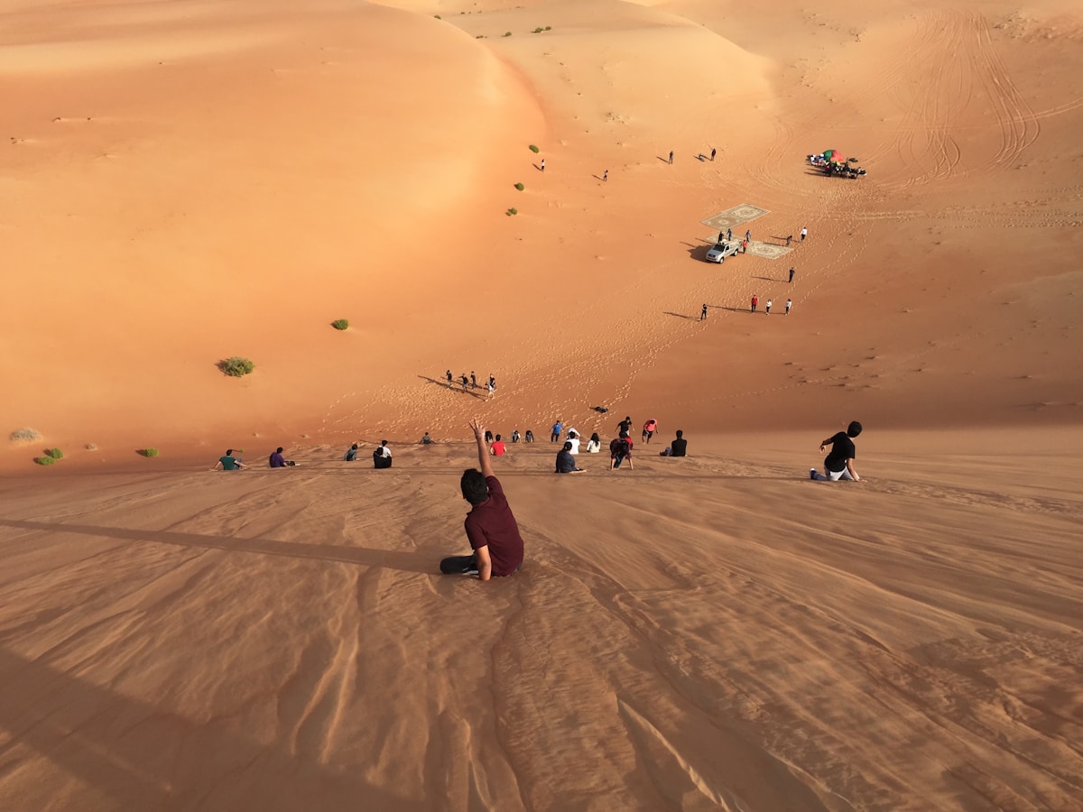 people walking on sand dunes Abu Dhabi