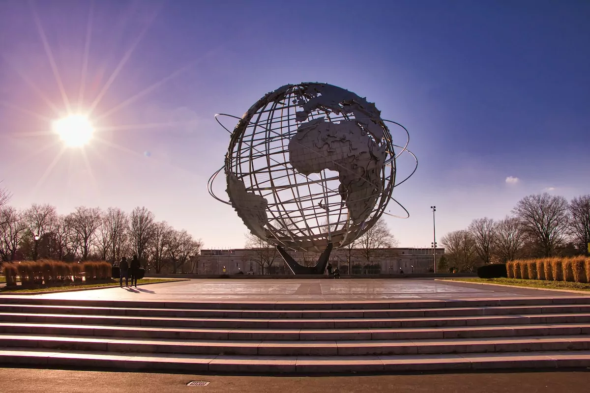 Queens New York City - black and white globe statue on brown wooden bench during night time