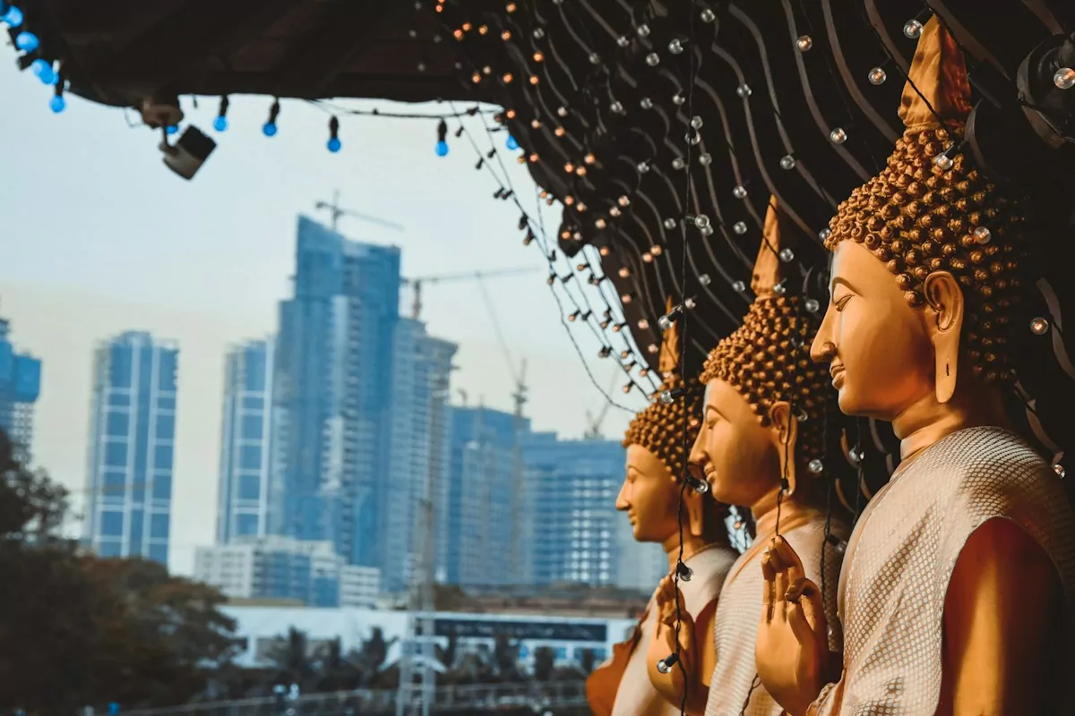 a row of buddha statues sitting next to each other - Gangaramaya Temple