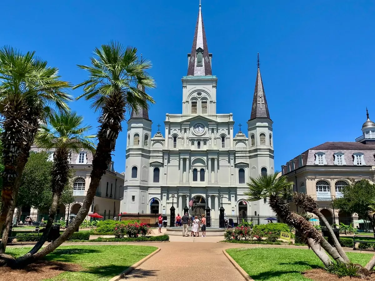 New Orleans USA - white concrete building near green trees under blue sky during daytime