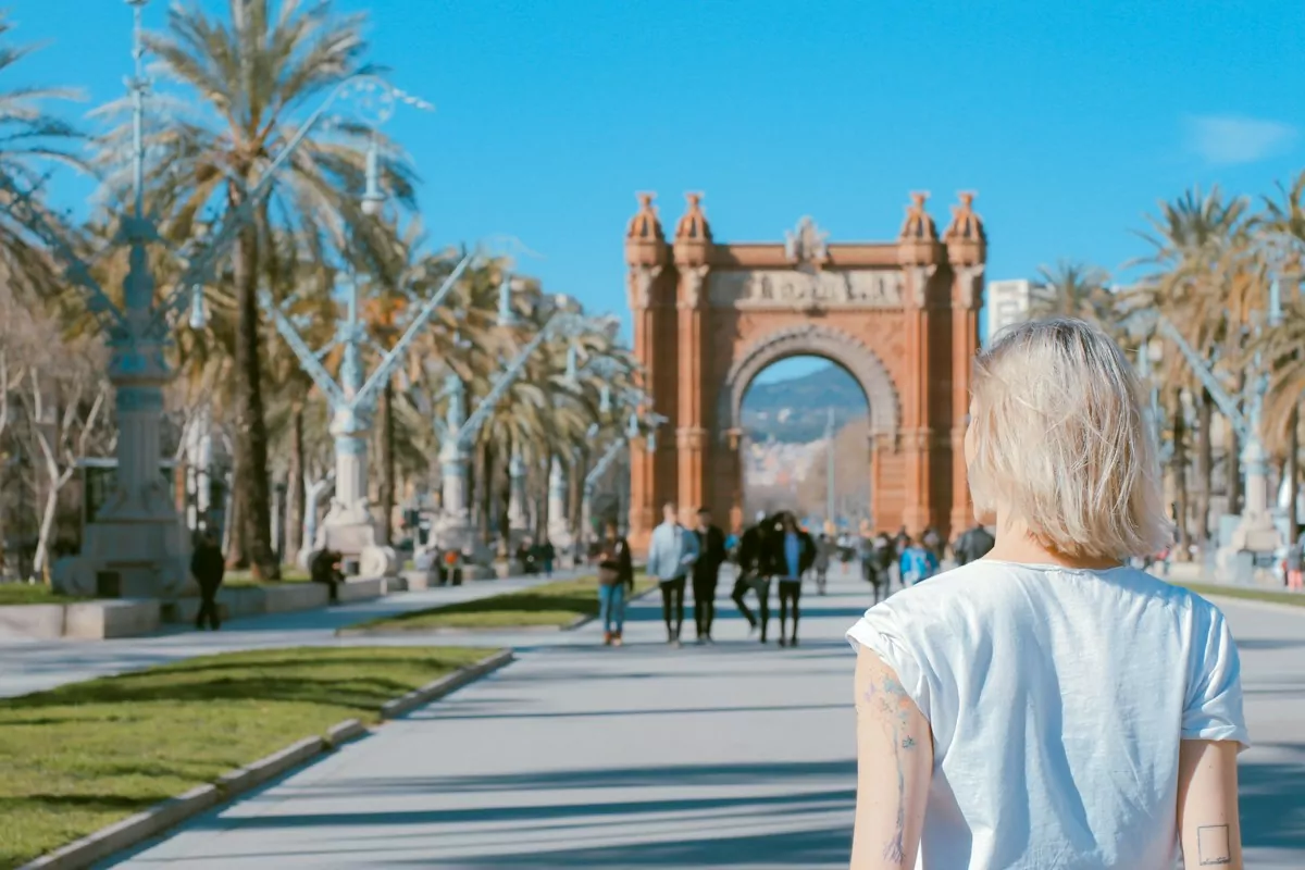 woman standing on road near concrete arch at daytime - Arco de Triunfo de Barcelona, Barcelona, Spain