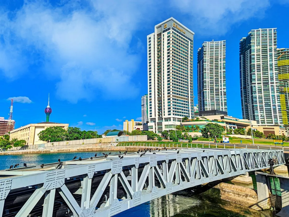 white bridge over river near city buildings during daytime - Colombo