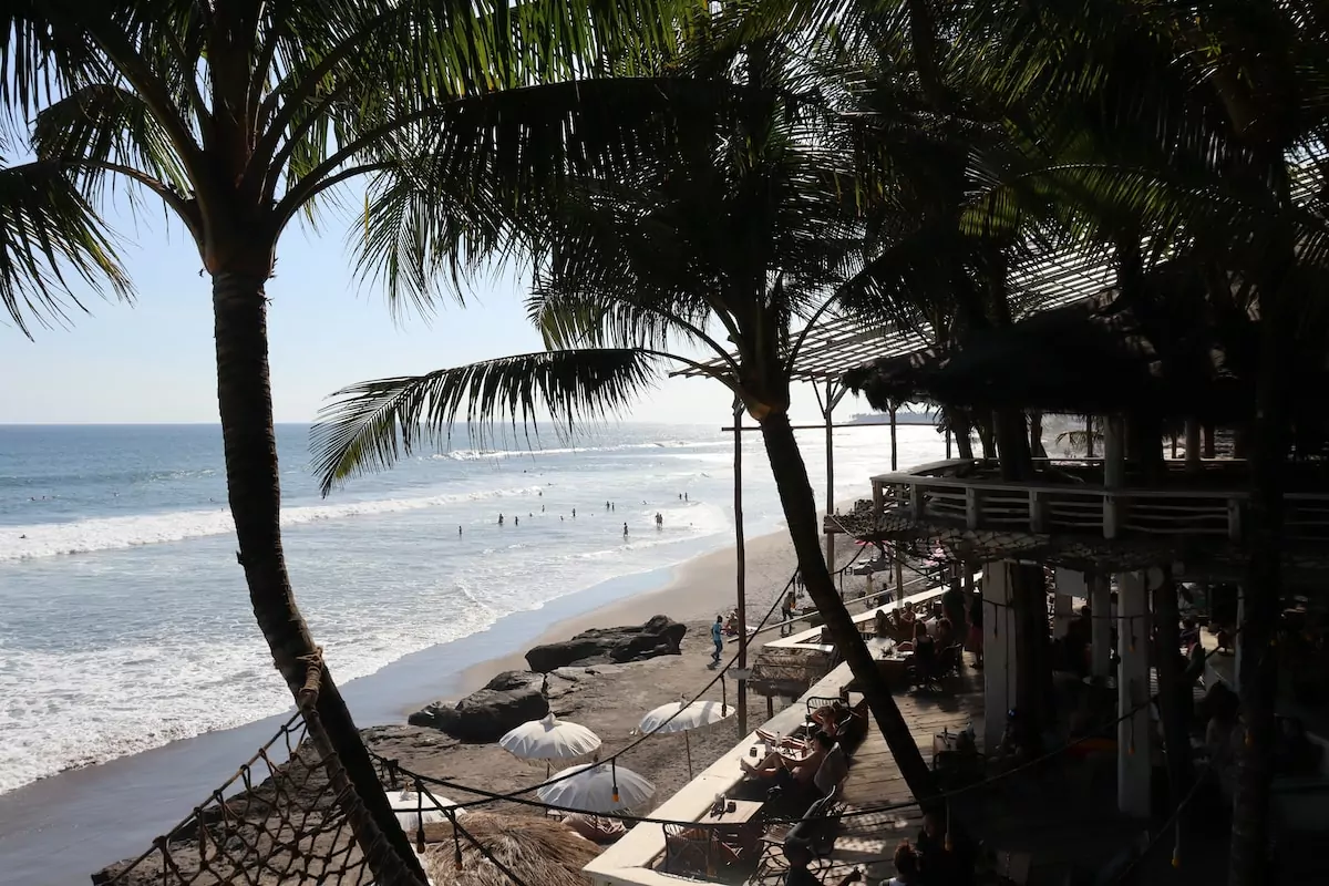 a beach with palm trees and a body of water La Brisa Canggu Bali