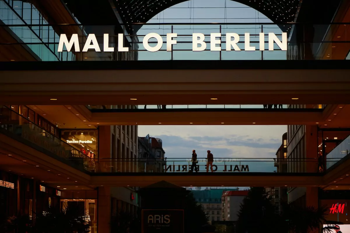 people walking on sidewalk during night time - Mall of Berlin