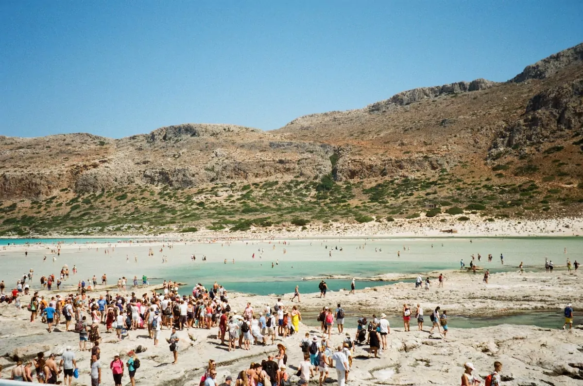 crowd of people standing and lying on beach during daytime - Beach Athens