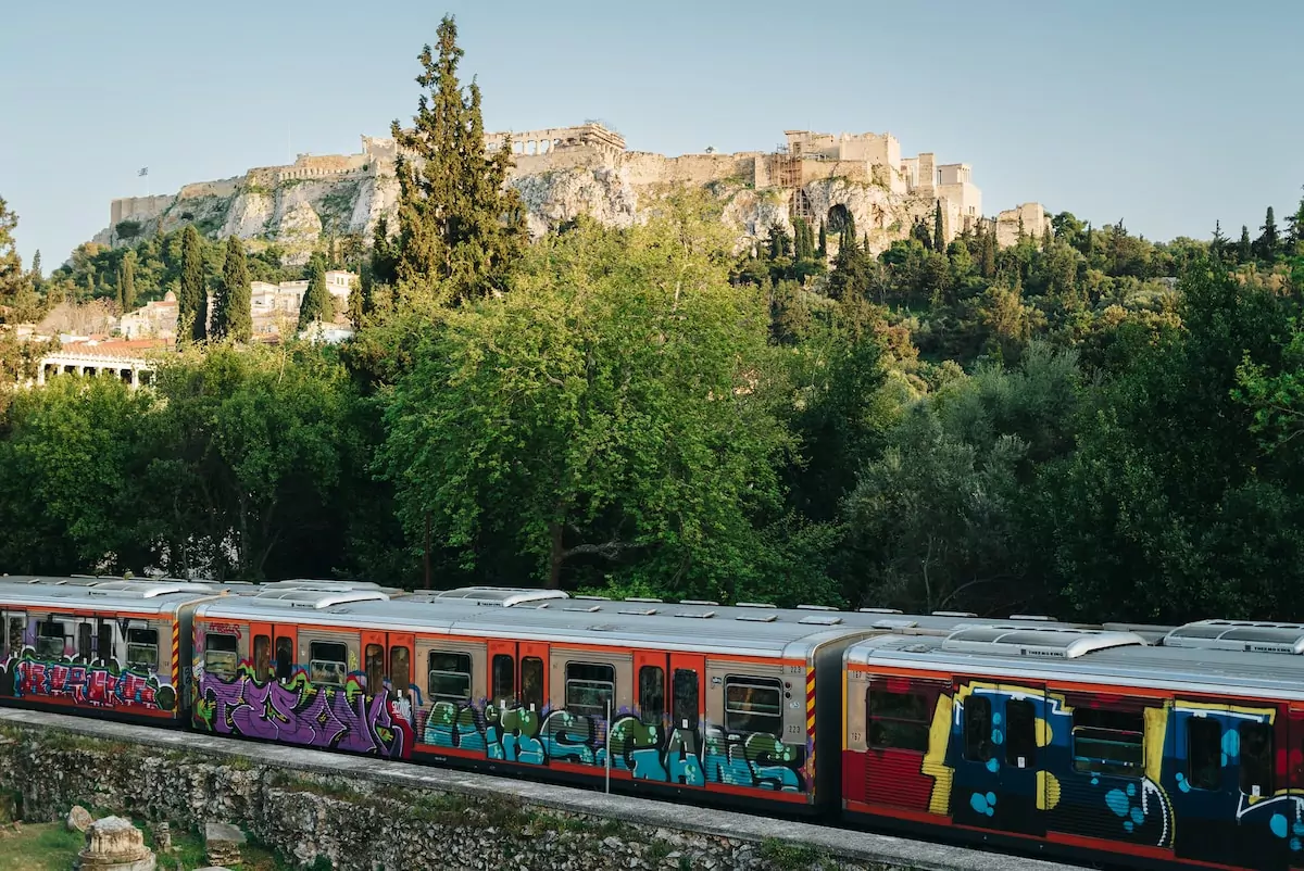 a train with graffiti painted on the side of it Athens