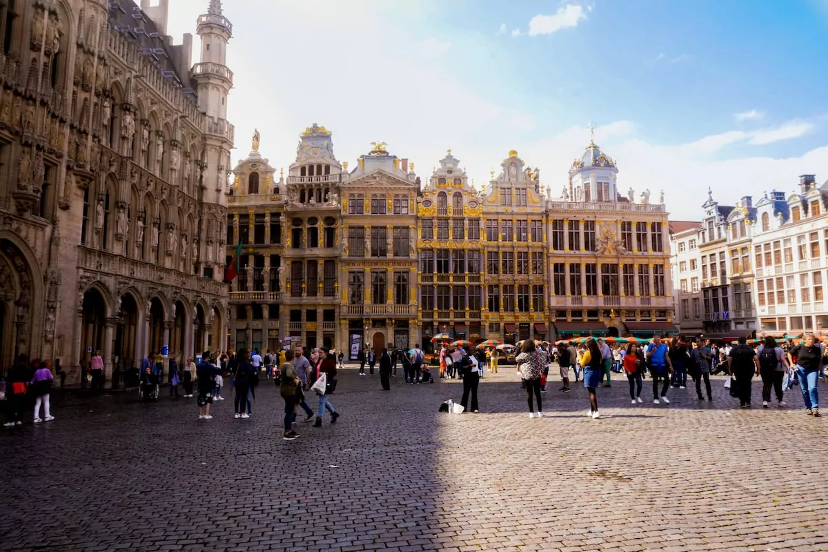 Brussels - people walking near Grand Palace, Brussels Town Hall under white and blue sky during daytime